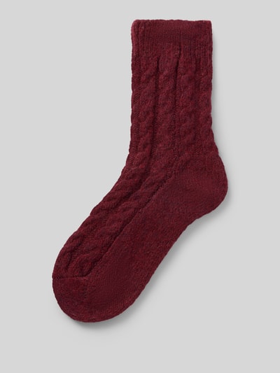 Produktfoto, weinrote Socken mit Zopfmuster und elastischem Rippbündchen, Modell 'Cosy' von camano, weiche Textur, Label-Detail