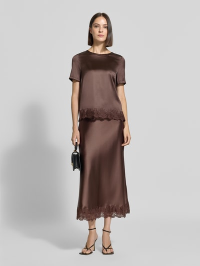 Vrouwenmodel draagt Midirok uit Satijn met Kant van Christian Berg Woman Selection, bruin, elastische materiaalmix, nauwsluitende pasvorm, totale lengte maat 36 90 cm, bandwijdte 38 cm, satijn met kant, volledige lichaamsopname vooraan.