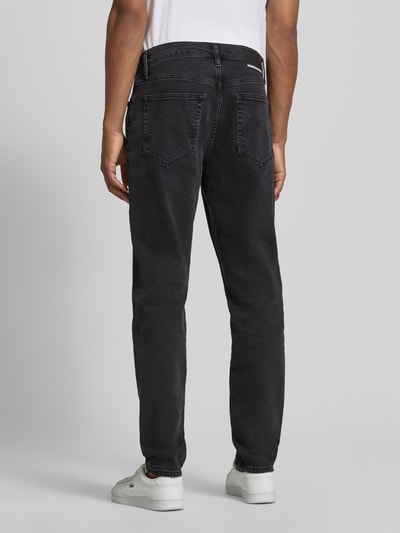 Männermodel trägt dunkelgraue Straight Fit Jeans aus Baumwoll-Lyocell-Mix Modell 'AARJO TARPA' von ARMEDANGELS, Ganzkörperansicht Rückansicht. Herren Straight Fit Jeans von ARMEDANGELS.