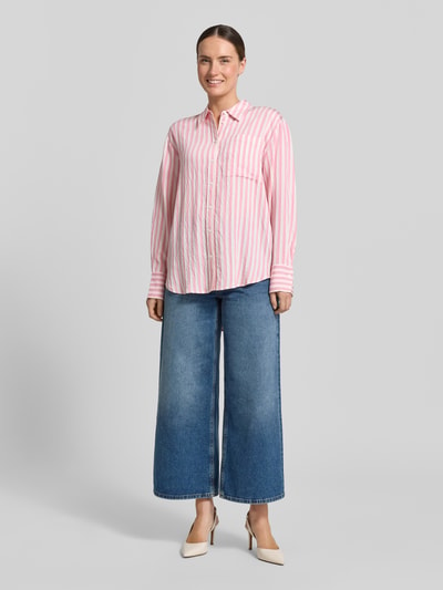 Frauenmodel trägt Relaxed Fit Bluse aus Viskose-Mix von Comma mit Hemdblusenkragen und Knopfleiste, rosa-weiß gestreift, Damen Bluse, Rückenlänge 76 cm, Ärmellänge 57 cm, Ganzkörperansicht von vorne.