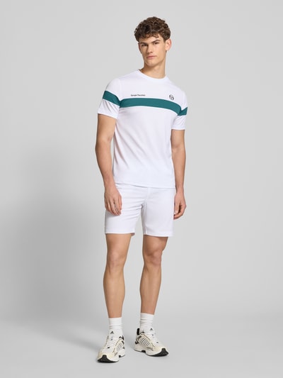 Männermodel trägt Shorts mit Logo-Print Modell 'GOCCIA' von SERGIO TACCHINI, weiß, Material-Mix mit Stretch-Anteil, Lockerer-Schnitt, Elastischer-Bund, Logo-Print, Bundweite 38 cm, Innenbeinlänge 19 cm, Ganzkörperansicht von vorne.