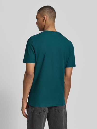 Męski model nosi T-Shirt mit Rundhalsausschnitt von MCNEAL w kolorze ciemnoturkusowym, krój slim fit, czysta bawełna, długość tyłu w rozmiarze M: 68 cm, pełny widok z tyłu.