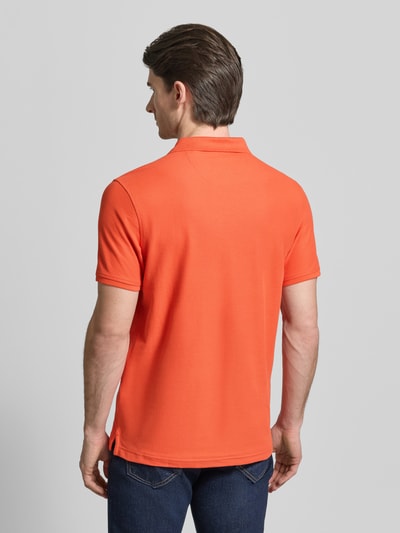 Männermodel trägt Poloshirt mit Logo-Stitching Modell 'PERFORMANCE' von Lerros in Orange, Baumwoll-Mix, Regular-Fit, Rückenlänge 73 cm, Ganzkörperansicht Rückansicht.