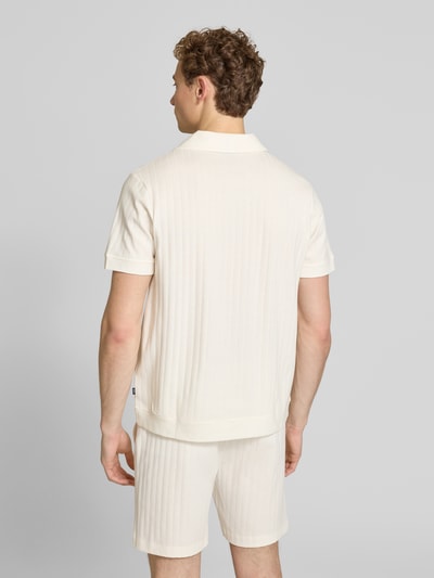 Männermodel trägt Regular Fit Poloshirt mit durchgehender Knopfleiste von JOOP! Collection aus reiner Baumwolle, Rückansicht, Ganzkörperansicht.