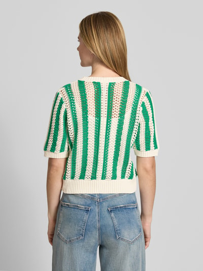 Frauenmodel trägt Cropped Cardigan mit Lochmuster Modell 'Siva' von Lollys Laundry im Baumwoll-Mix, Strick-Optik, Halbarm, grün-creme Farben, Knopfleiste, elastische Abschlüsse, Rückenlänge bei Größe S 51 cm, Ärmellänge 27 cm, Ganzkörperansicht Rückansicht.