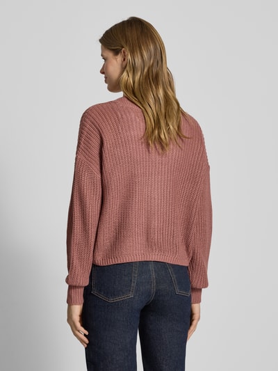 Frauenmodel trägt Regular Fit Strickjacke mit einreihiger Knopfleiste Modell 'CAROL NICE' von Only, einfarbig, Strickoptik, cropped, Rückenansicht.