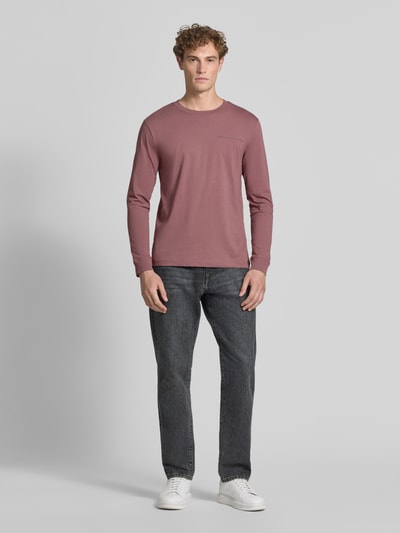 Mężczyzna nosi Męski t-shirt Regular Fit T-Shirt aus reiner Baumwolle Modell 'solid' von Tom Tailor Denim w kolorze zgaszonego różu, prosta faktura, Ganzkörperansicht von vorne