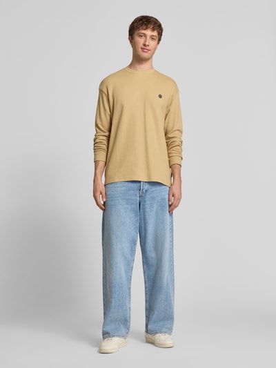 Männermodel trägt Longsleeve aus Baumwolle Modell 'FILLIP' von Blend in Beige mit Rundhalsausschnitt, Gerader-Schnitt, Label-Detail; Ganzkörperansicht von vorne. Rückenlänge bei Größe M: 70 cm.