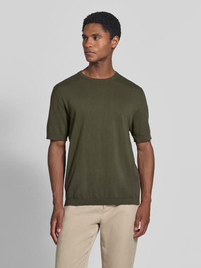 Männermodel trägt Regular Fit T-Shirt aus reiner Baumwolle Modell 'TORINO' von SELECTED HOMME in Olivgrün, unifarben, Rundhals, kurzarm, Struktur mit geripptem Abschluss, Ganzkörperansicht von vorne.