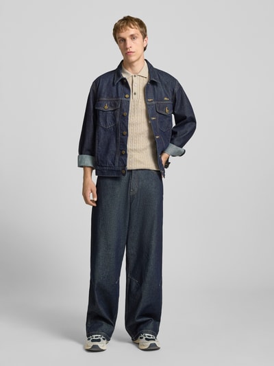 Männermodel trägt Slim Fit Strick-Poloshirt mit Zopfmuster Modell 'EMIL' von Jack & Jones im Baumwoll-Mix, Ganzkörperansicht von vorne.