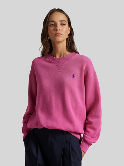 Modelka nosi Bluza 'Sweatshirt mit Label-Stitching' od Polo Ralph Lauren, mieszanka bawełny, luźny krój, prążkowane wykończenia, okrągły dekolt, wyhaftowane logo, kolor różowy; widok całej sylwetki z przodu.