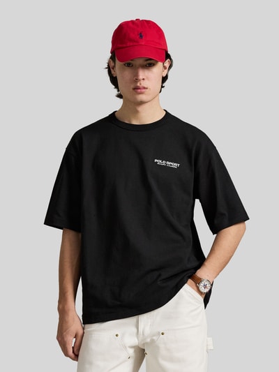 Männermodel trägt Regular Fit T-Shirt aus reiner Baumwolle von Polo Ralph Lauren in Schwarz, unifarben, Label Print, Nahaufnahme Oberkörper.