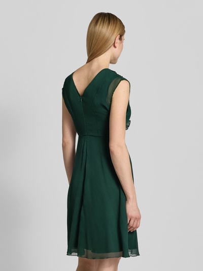 Modelka kobieca ma na sobie Knielanges Kleid mit Rüschen und V-Ausschnitt od Zero, zielony szyfon, taliowany krój, długość do kolan, dekolt w serek, falbany, rękawy z falistym wykończeniem, zamek błyskawiczny z tyłu, długość tyłu w rozmiarze 36: 84 cm, szerokość w rozmiarze 36: 40 cm, całkowity widok z tyłu