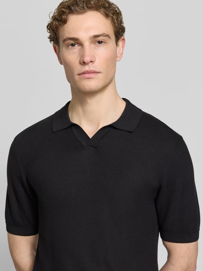Männermodel trägt Slim Fit Poloshirt mit Viskose-Anteil von Roy Robson in Schwarz mit Strick-Optik, Strukturmuster, Nahaufnahme Oberkörper. Baumwoll-Mix mit Viskose-Anteil, Kurzärmelig, elastische Abschlüsse, Rückenlänge 67 cm, Ärmellänge 27 cm bei Größe M.