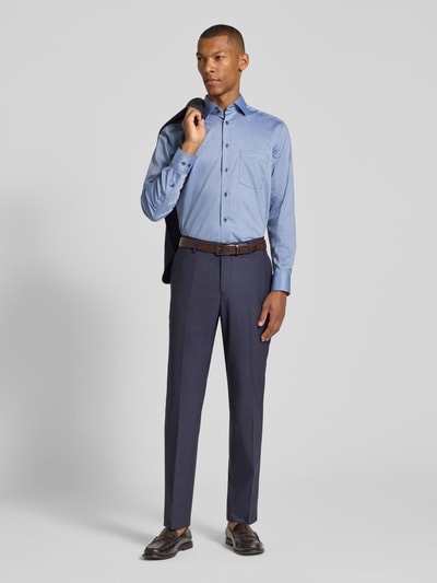 Männermodel trägt Modern Fit Businesshemd aus reiner Baumwolle von OLYMP in Hellblau und dunkelblaue Stoffhose, Ganzkörperansicht von vorne, Herren Businesshemd von OLYMP.