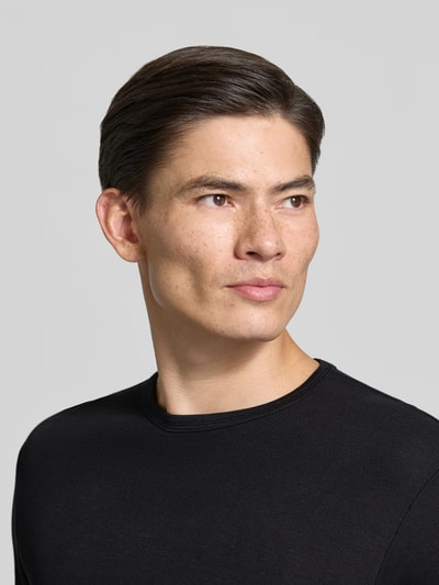 Männermodel trägt Regular Fit Longsleeve aus reiner Baumwolle Modell 'Basic' von Lindbergh, schwarze Farbe, Nahaufnahme Oberkörper.