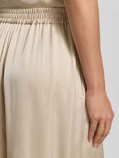 Frauenmodel trägt Regular Fit Wide Leg Hose aus reiner Viskose Modell 'TALIA' von BOSS Orange in Optik: Unifarben, Satin, Materialverarbeitung reine Viskose, Detailaufnahme seitlicher Eingrifftasche.