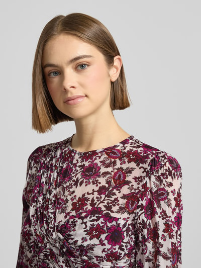 Frauenmodel trägt eng anliegendes Freizeitkleid aus reiner Viskose Modell 'MANILA' von Pepe Jeans mit floralem Allover-Muster, Nahaufnahme Oberkörper.