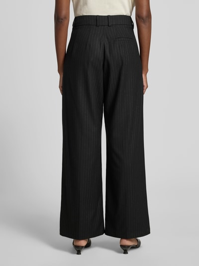 Frauenmodel trägt Wide Fit Hose mit Viskose-Anteil von black palms in Schwarz mit Bundfalten, Gesäßtasche, Elastischer-Material-Mix, Ganzkörperansicht Rückansicht.