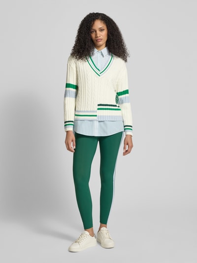 Frauenmodel trägt Relaxed Fit Pullover mit Lanawoll-Anteil von Marc Cain, Baumwoll-Mix, V-Ausschnitt, creme mit grünen Streifen, Ganzkörperansicht von vorne.