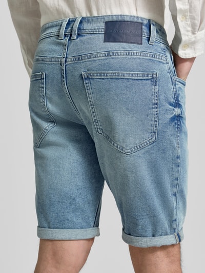 Männermodel trägt Regular Fit Jeans Bermudas aus Baumwoll-Mix von Tom Tailor in Denim-Optik mit Label-Patch, Ganzkörperansicht Rückansicht.