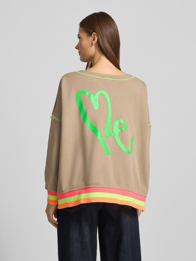 Vrouwenmodel draagt Oversized Sweatshirt met geribde boorden van miss goodlife in beige met groene statement-print, kleuraccenten, rechte rugaanzicht.