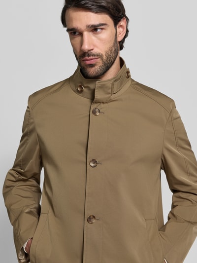 Männermodel trägt Mantel mit durchgehender Knopfleiste von CINQUE in Beige, hoher Stehkragen mit Riegel, Eingrifftaschen, Nahaufnahme Oberkörper. Gerade Passform, Rückenlänge 83 cm, Schulterbreite 42 cm, Brustweite 40 cm, Ärmellänge 66 cm.