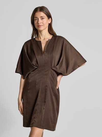 Frauenmodel trägt Knielanges Kleid mit Viskose-Anteil Modell 'VIANNA' von Copenhagen Muse in Braun mit 3/4-Arm, Satin, V-Ausschnitt, Tailliert, Nahaufnahme Oberkörper.