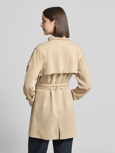 Frauenmodel trägt Trenchcoat mit Bindegürtel Modell 'CORDELIA' von Frieda & Freddies aus beigem Material-Mix mit Stretch-Anteil, Rückenansicht.