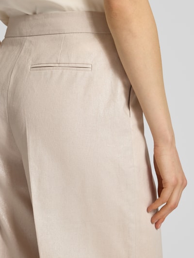 Vrouwenmodel draagt Leinenhose mit Bügelfalte und Eingrifftaschen van Christian Berg Cocktail, lichtbeige, linnenmix met katoen, loose fit, Franse steekzakken, achterzak met paspel, detailopname heup en bovenbeen.