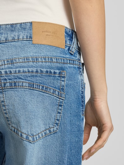 Vrouwenmodel draagt Wide Fit Jeans im 5-Pocket-Design van Gina Tricot in lichtblauw katoenmix, detailopname heup en achterzak.
