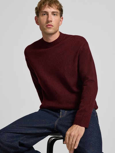 Männermodel trägt Relaxed Fit Strickpullover aus Material-Mix mit Baumwoll-Anteil von REVIEW in Dunkelrot, Strukturstrick, Nahaufnahme Oberkörper. Rückenlänge 66 cm, Ärmellänge 61 cm, Stehkragen, elastische Abschlüsse.