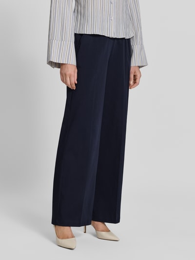 Frauenmodel trägt Stoffhose mit französischen Eingrifftaschen Modell 'Mucia Base' von OPUS PANTS in Dunkelblau, Baumwoll-Mix mit Stretch-Anteil, Loose-Fit, Ganzkörperansicht von vorne.