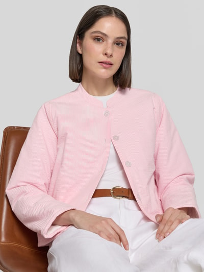 Frauenmodel trägt Jacke mit Stehkragen Modell 'Emilia' von LOLLYS LAUNDRY aus Reine Baumwolle, Regular-Fit, in zartem Rosa mit feinen weißen Streifen, sichtbare Knopfleiste und strukturierter Oberfläche, Rückenlänge 49 cm, Schulterbreite 40 cm, Brustweite 55 cm, Ärmellänge 62 cm, Nahaufnahme Oberkörper.