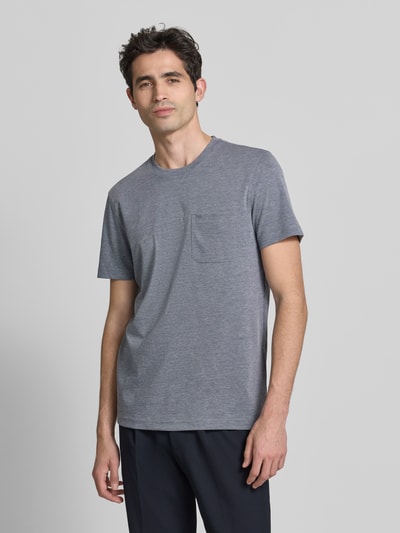 Męski model nosi T-shirt mit Rundhalsausschnitt und Brusttasche von Christian Berg Men, mieszanka bawełny, krój regular fit, długość tyłu 72 cm w rozmiarze M, kolor szary, gładka faktura. Ganzkörperansicht von vorne.