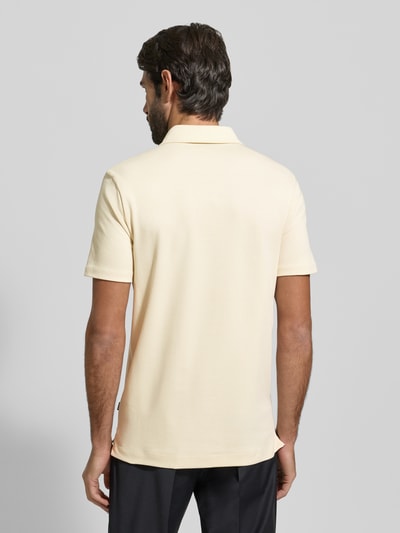 Männermodel trägt Regular Fit Poloshirt aus reiner Baumwolle Modell 'PALOSH' von BOSS, Optik: Unifarben, Label-Print, Ganzkörperansicht Rückansicht.