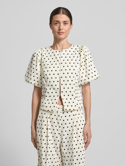 Frauenmodel trägt Slim Fit Bluse mit Puffärmeln Modell 'ANELA DOT' von Neo Noir aus Material-Mix mit Stretch-Anteil, Rundhalsausschnitt, schwarz-weiß gepunktet, Ganzkörperansicht von vorne.
