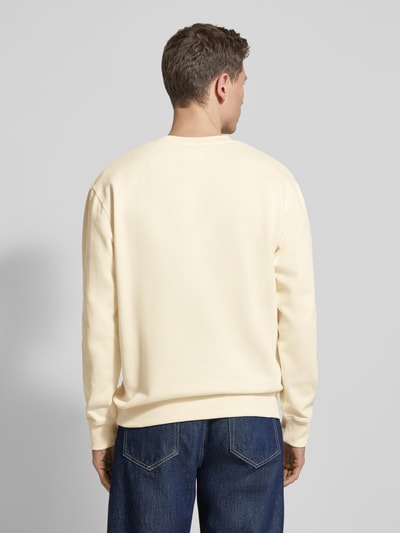 Männermodel trägt Sweatshirt mit Logo-Print Modell 'NOEL' von Wood Wood in Creme, lockere Passform, reine Baumwolle, Ganzkörperansicht Rückansicht.