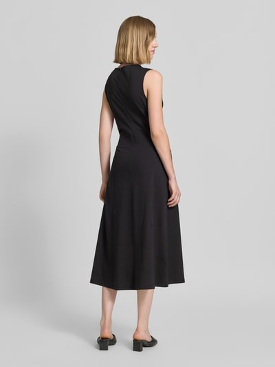 Vrouwenmodel draagt vrijetijdsjurk van katoenmix in effen kleuren van s.Oliver RED LABEL, getailleerd, midilengte, boothals, uitlopend, mouwloos, jersey materiaalverwerking, achteraanzicht volledige lichaamsopname.