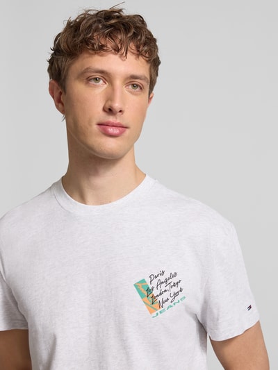 Männermodel trägt Regular Fit T-Shirt aus reiner Baumwolle von Tommy Jeans, unifarben mit Label Print, Nahaufnahme Oberkörper