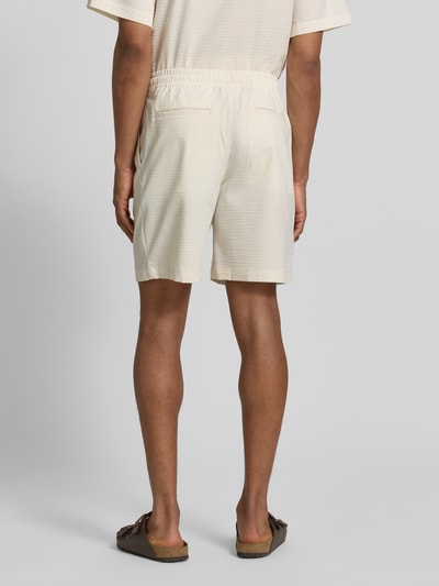 Männermodel trägt Loose Fit Shorts aus Baumwoll-Mix von Lacoste, Optik:Allover-Muster, Passform: Regular-Fit, Materialverarbeitung: Seersucker, Ganzkörperansicht Rückansicht.