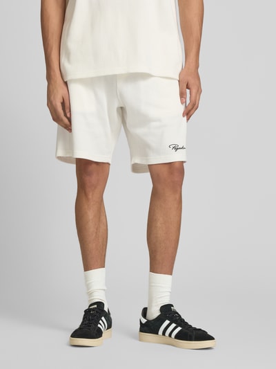 Männermodel trägt Shorts mit Logo-Stitching und elastischem Bund von Pegador in Weiß, Reine Baumwolle, Loose-Fit, Feinripp, Ganzkörperansicht von vorne.
