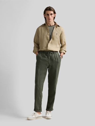 Męski model nosi Slim Fit Freizeithemd aus reinem Leinen od Polo Ralph Lauren, beżowa koszula z długim rękawem, len, jednolita, widok całej sylwetki z przodu.