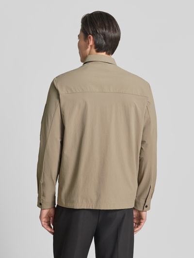 Męski model nosi Relaxed Fit Overshirt mit Label Patch model 'ST_GLOBE HEXA L' od BOSS Green, efekt: jednolity kolor, wykładany kołnierz, listwa z zatrzaskami, aplikacja z metką, długi rękaw, hydrofobowy, wpuszczane kieszenie, brustasza, Ganzkörperansicht Rückansicht.