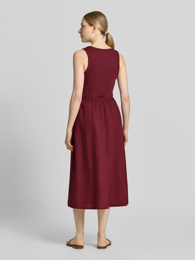 Frauenmodel trägt bordeauxrotes Fit and Flare Freizeitkleid aus reiner Baumwolle von s.Oliver RED LABEL, glatte Textur, Ganzkörperansicht Rückansicht.