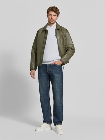 Męski model trägt Sweatshirt mit Label-Patch von Scotch & Soda aus bawełna, luźny krój, okrągły dekolt, prążkowane wykończenia, Długość tyłu w rozmiarze M: 64 cm, Długość rękawów w rozmiarze M: 64 cm, Ganzkörperansicht von vorne.