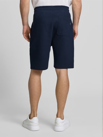 Männermodel trägt Shorts mit Strukturmuster und Tunnelzug von Lerros, dunkelblau, Baumwoll-Mix mit Stretch-Anteil, Ganzkörperansicht Rückansicht.