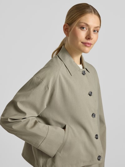 Modelka kobieca nosi Jacke mit Eingrifftaschen Modell 'KELLY' od Samsøe Samsøe, szaro-beżowa, krój regular fit, materiał z domieszką wiskozy, guziki, kieszenie, szerokość w rozmiarze S: 54 cm, długość tyłu: 54 cm, długość rękawa: 58 cm, zbliżenie na górną część ciała z przodu.