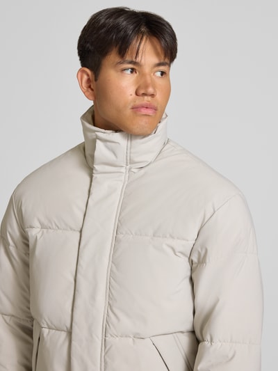 Männermodel trägt gewatteerd jack met opstaande kraag, regular fit, Model 'SOHO' van JACK & JONES, beige, detailopname bovenlichaam.