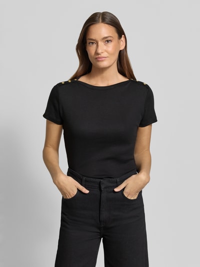 Frauenmodel trägt Slim Fit T-Shirt aus reiner Baumwolle von Tommy Hilfiger in Schwarz, unifarben mit Logo-Detail und Zierknöpfen, Ganzkörperansicht von vorne.